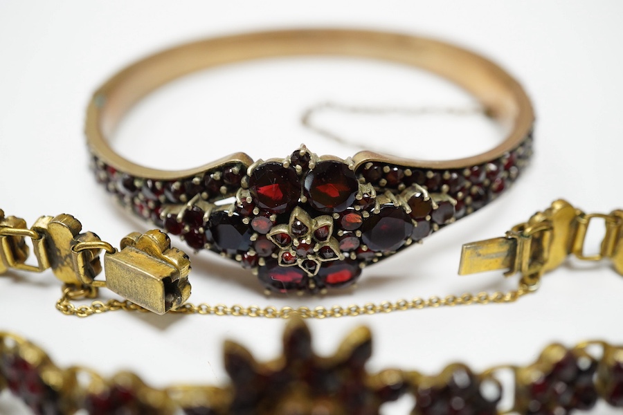 Three items of gilt white metal and garnet paste cluster set jewellery, comprising a bracelet, bangle and pair of Czechoslovakian earrings. Condition - fair